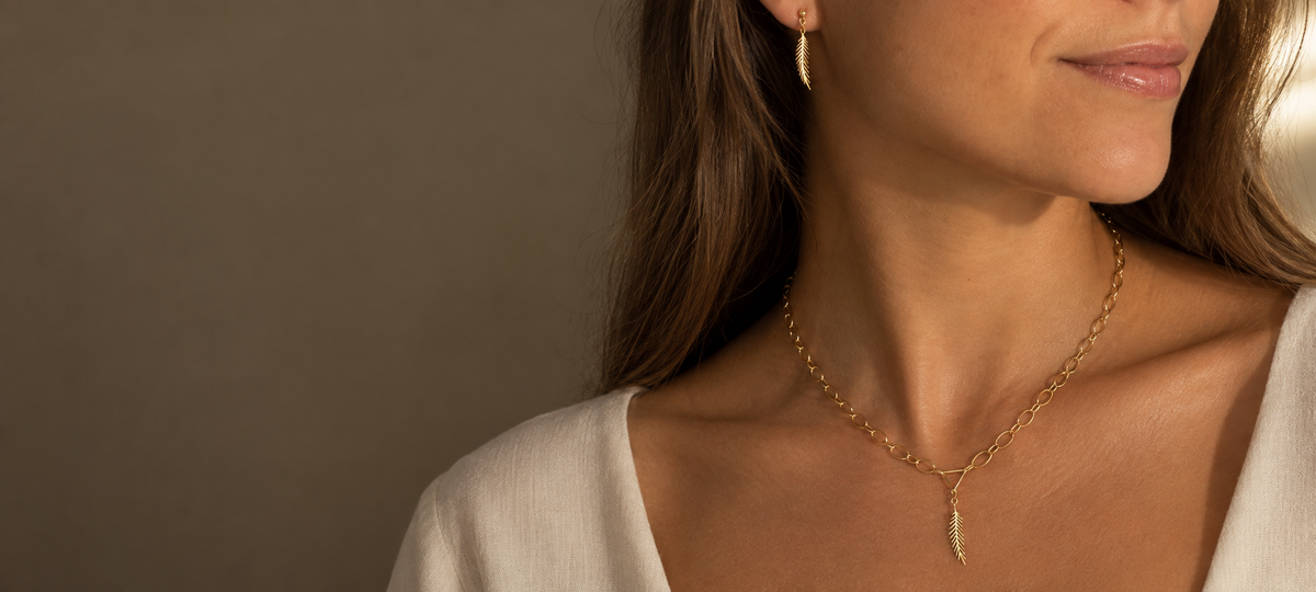 Wear Your Power collection in 14k solid gold by Larisa Beaumont displayed on a silk fabric.