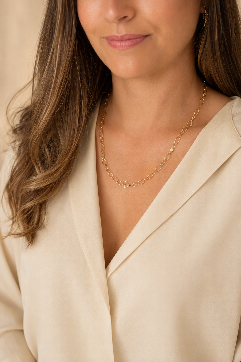 Woman wearing a solid 14k gold chain necklace by Larisa Beaumont, everyday British jewellery, in a cream blouse